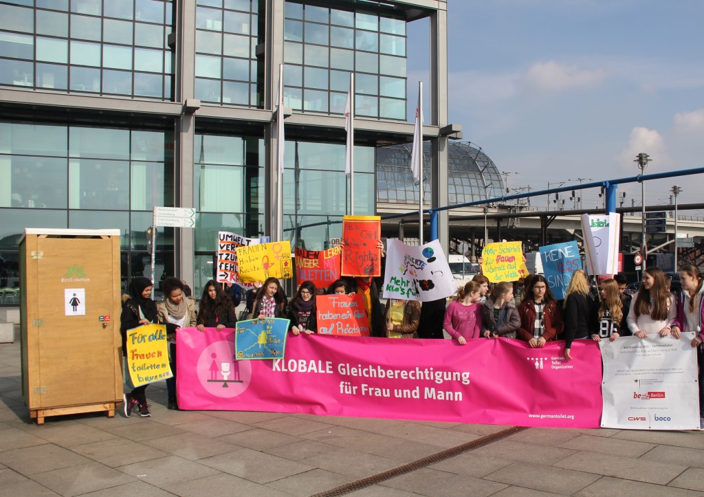 students in front of a toilet in Berlin during International Women's Day